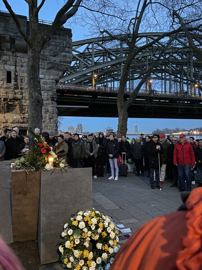 Eine Gruppe von Menschen steht vor einer Brücke, um an den Holocaust-Gedenktag zu erinnern.